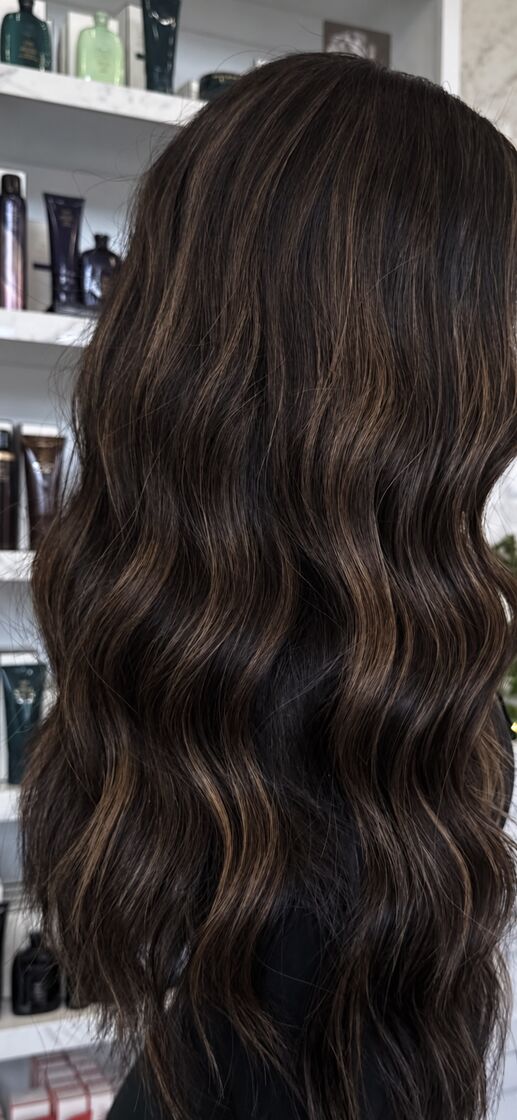 Real salon result showing glossy dimensional brunette waves.